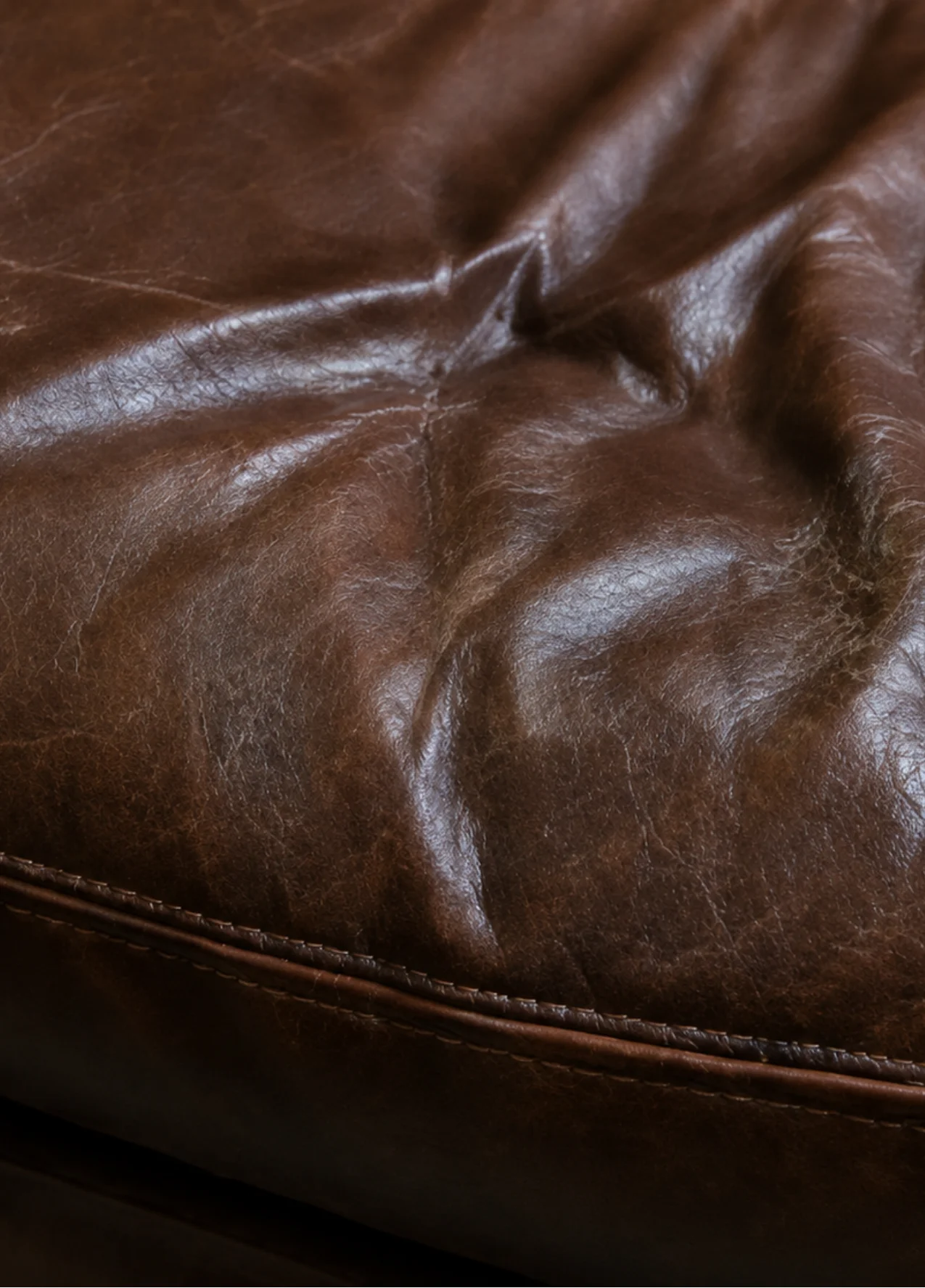 Worn hotel lobby chair leather before commercial repair