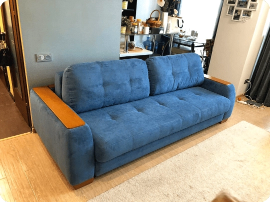 Blue reupholstered sofa after full restoration with new fabric and cushions in New York apartment