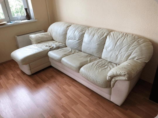 Restored beige leather sofa after professional reupholstery in New York