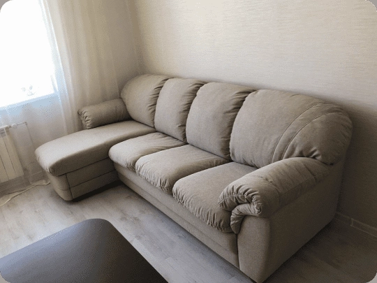 Beige leather sofa after full restoration and reupholstery in New York living room