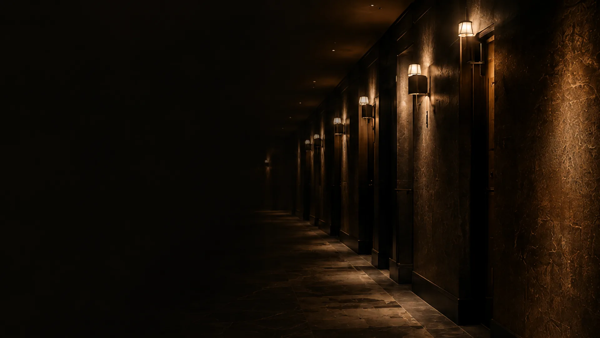 A lit building corridor in the evening while the rest of the floor is closed, the ordinary week still running around the work