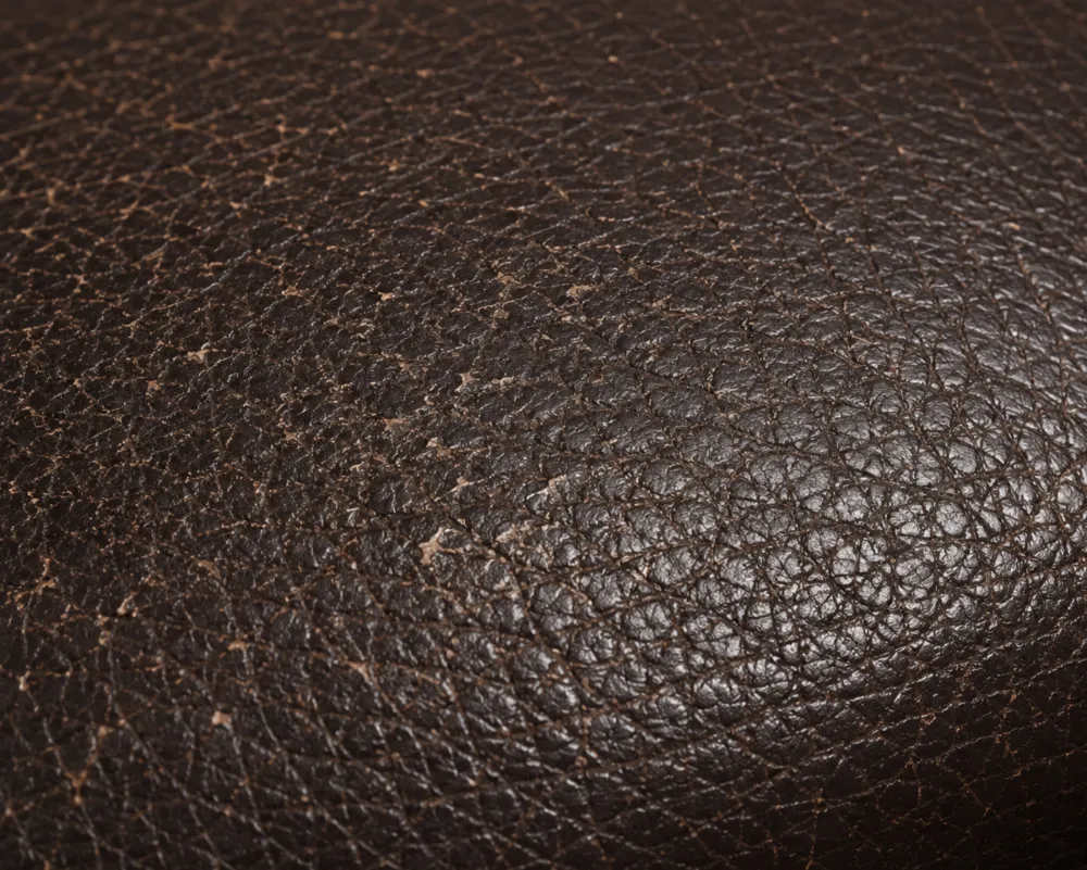 Fine network of micro-cracks across a faded leather surface