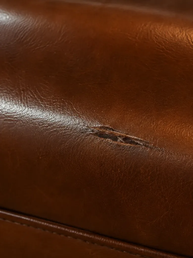 Macro of a clean cut through the hide of a tan leather booth seat