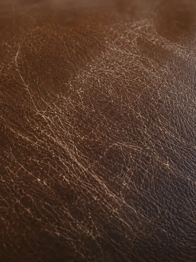 Macro of crazing across the finish of a brown leather booth seat