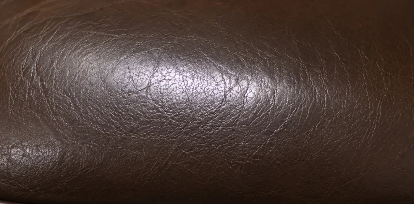 A darkened, glossy band on a corrected grain leather headrest where body oil has built up
