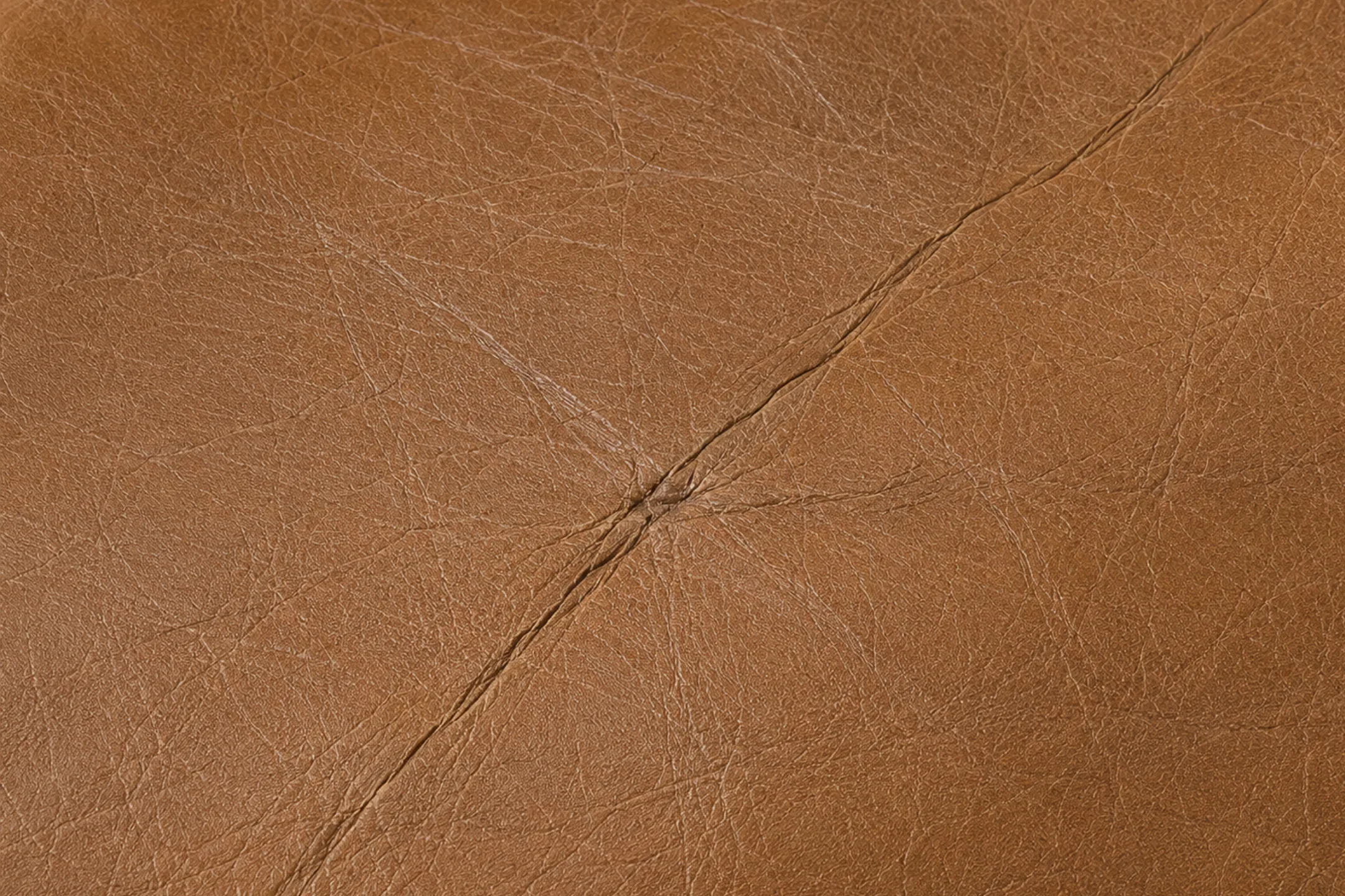 Dried-out brown semi-aniline leather covered in a fine network of crazing across the grain