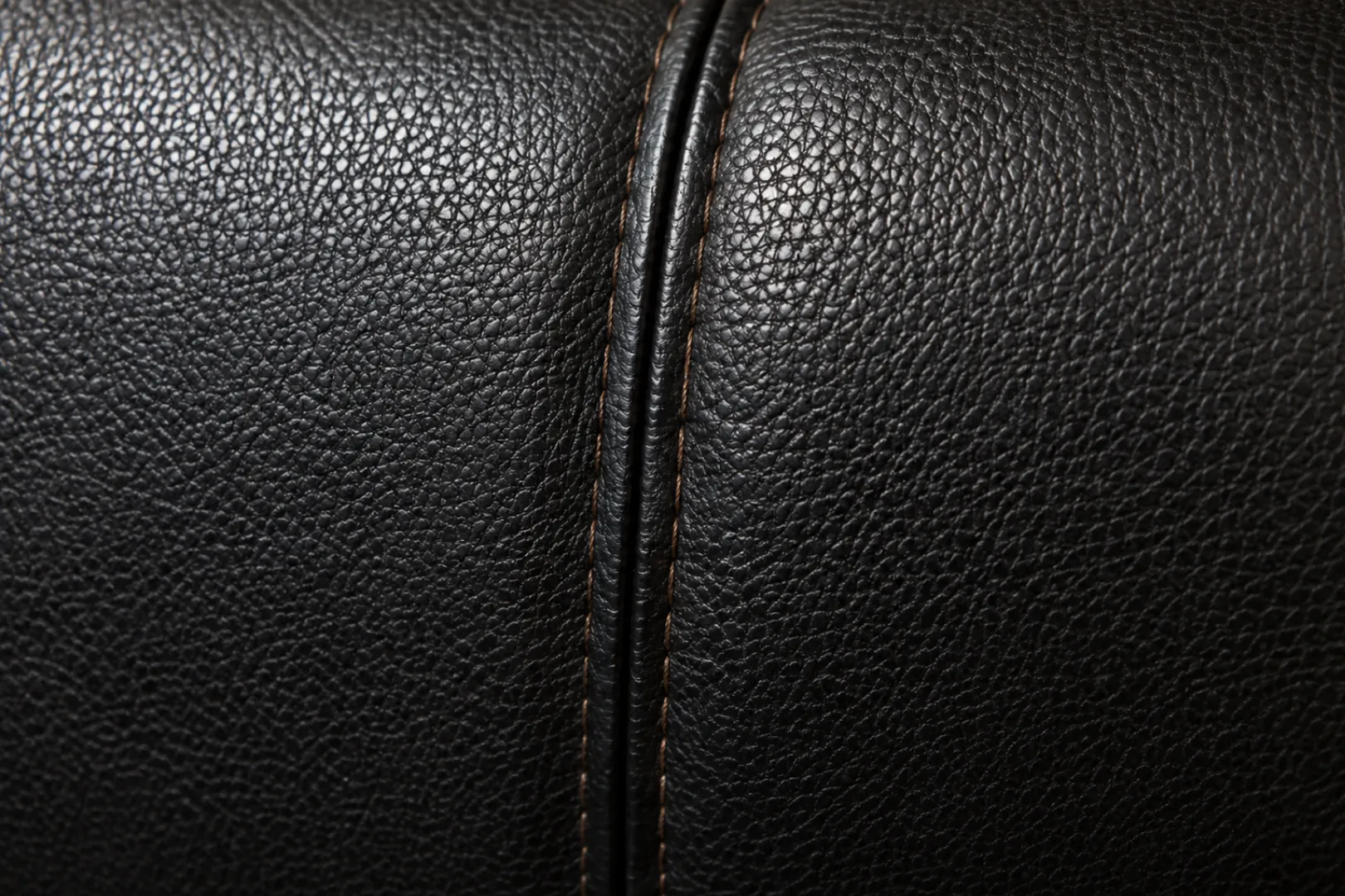 Embossed leather grain pattern running across a seam on a commercial banquette