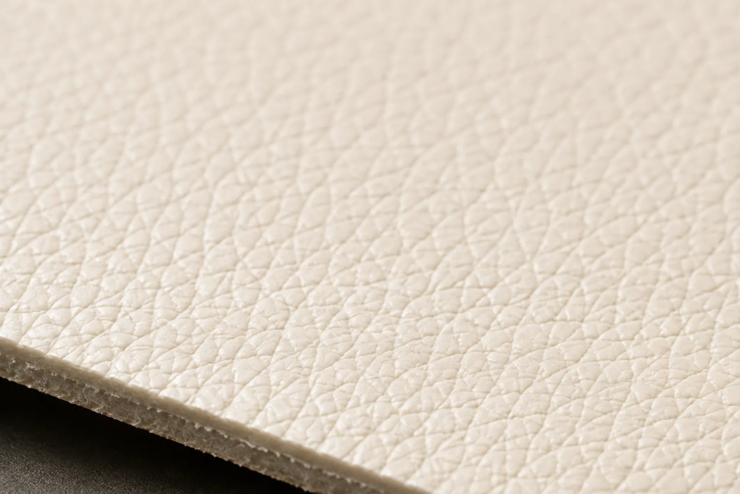 A close-up of embossed faux leather grain, the pebble pattern repeating at regular intervals