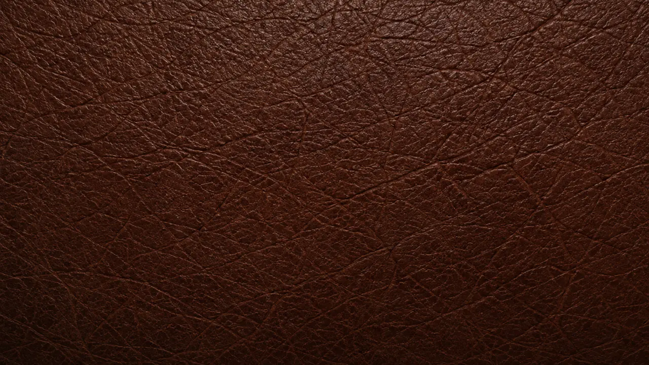 Macro of leather that has begun to crack, with fine splits opening across the grain.