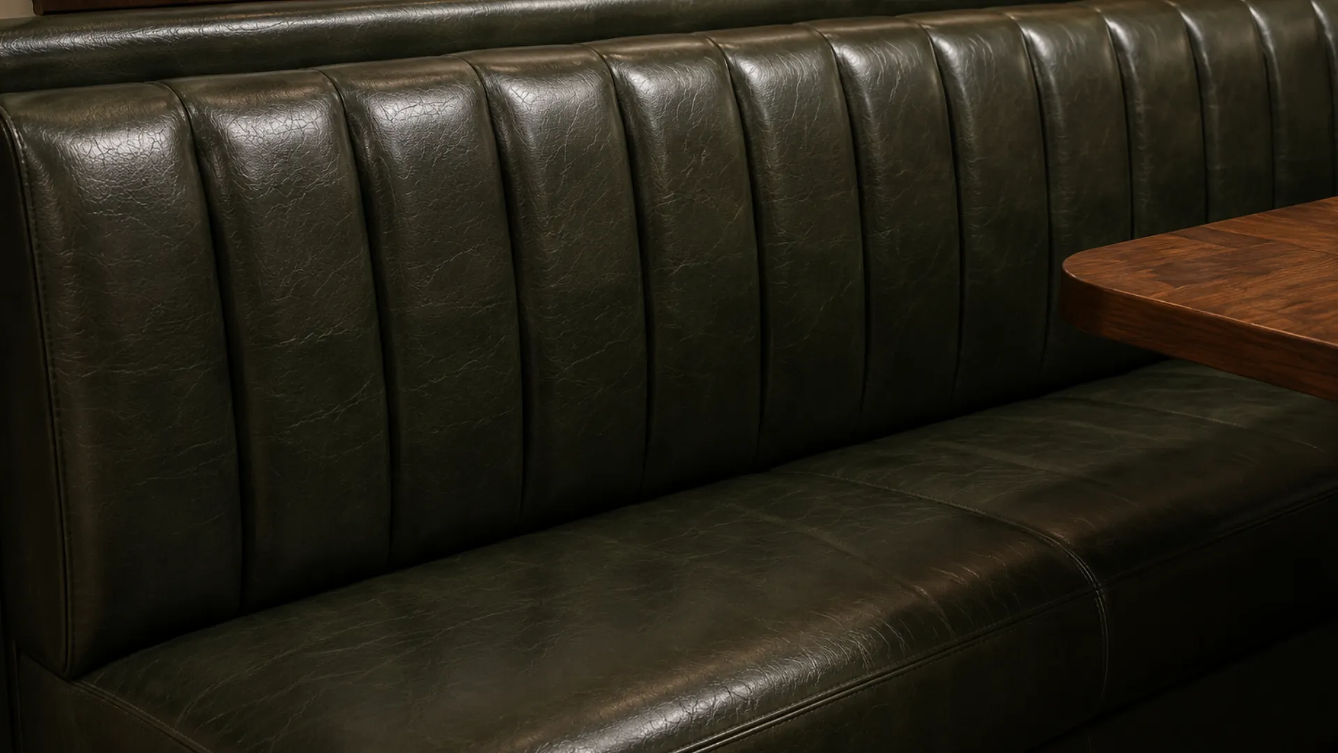 Green leather banquette bay recovered in full so no new panel sits beside an original