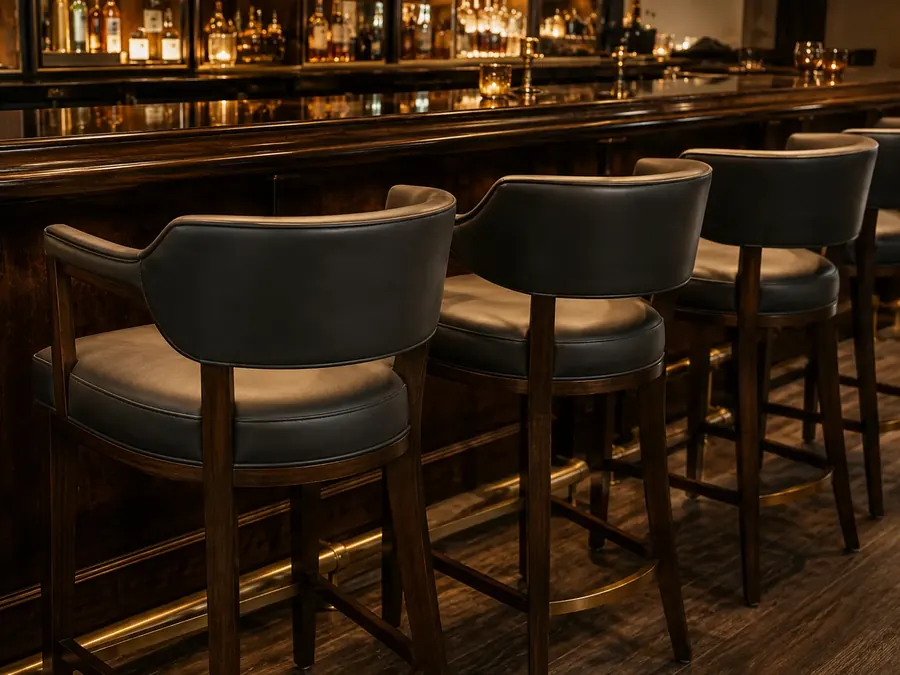 Row of upholstered bar stools along a hotel bar counter