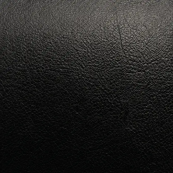 Macro swatch of black full-grain leather with natural pebble grain