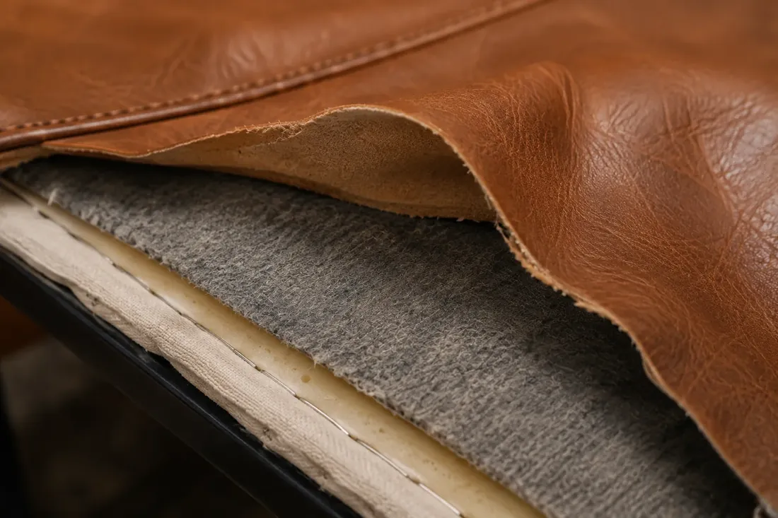 Leather cushion cover peeled back to show the insert inside it
