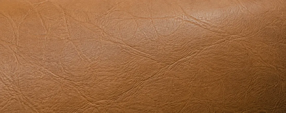 Tan leather panel with colour faded pale and flat across the centre