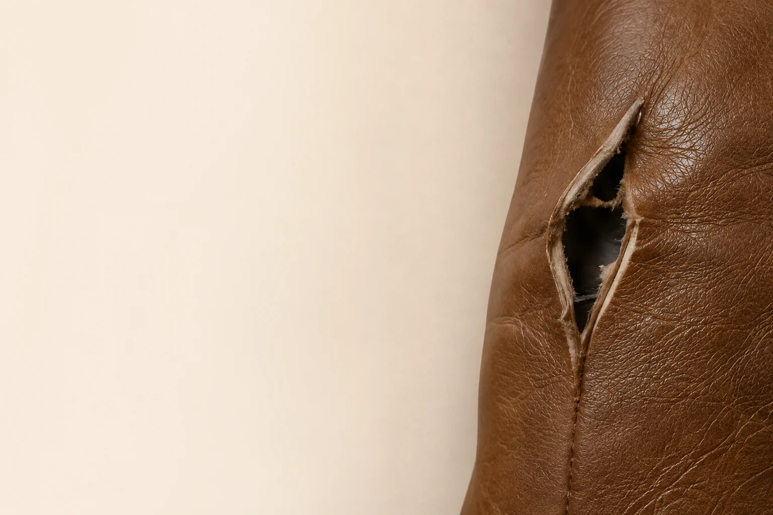 Technician working a tear in the leather of a law office chair