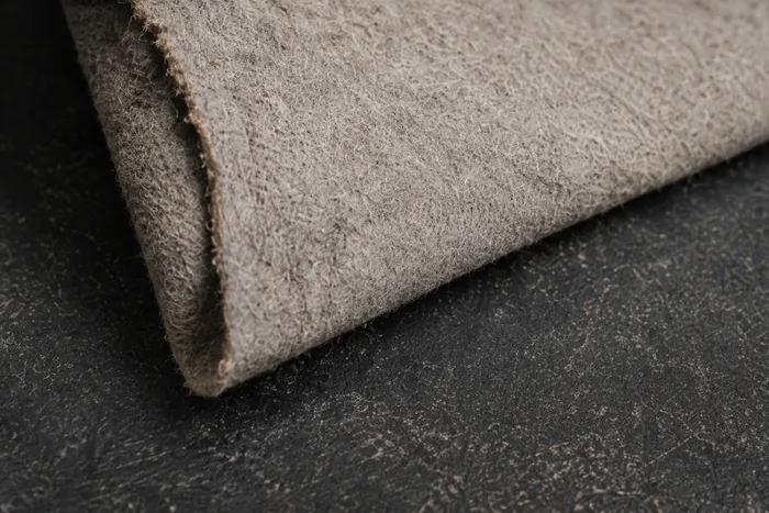 A hide folded back to show its flesh side, a soft fibrous grey-brown surface with a fine nap and no pattern anywhere in it