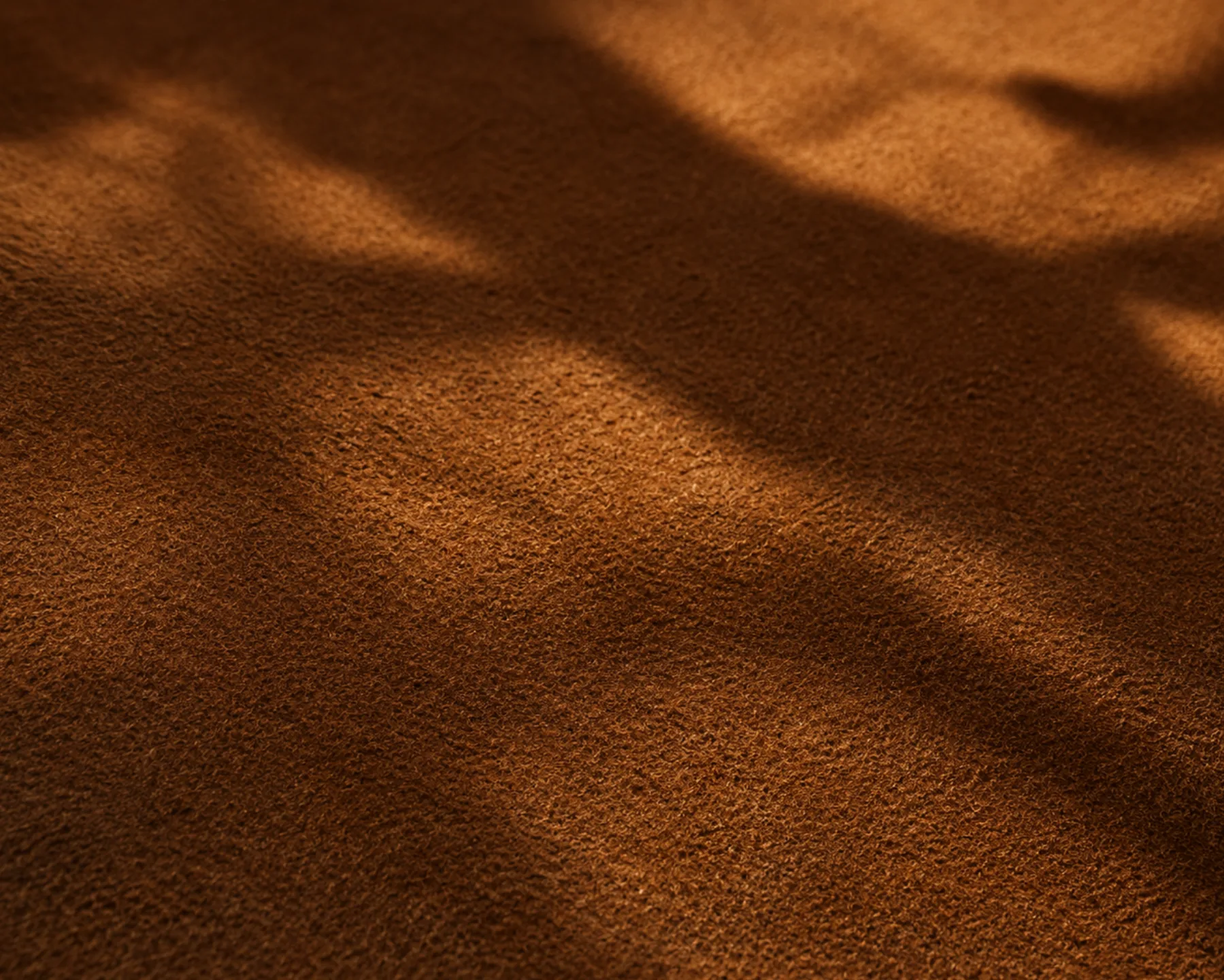Raking light across a nubuck panel, throwing the nap into alternating light and dark bands