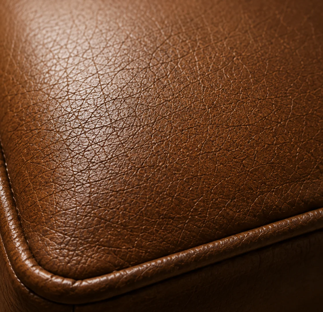 Close-up of pigmented leather showing a fine network of micro-cracks in the topcoat along a flex line