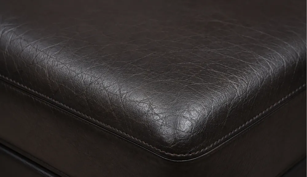 Close-up of a bonded leather seat cushion top showing dulled, softly wrinkled surface finish