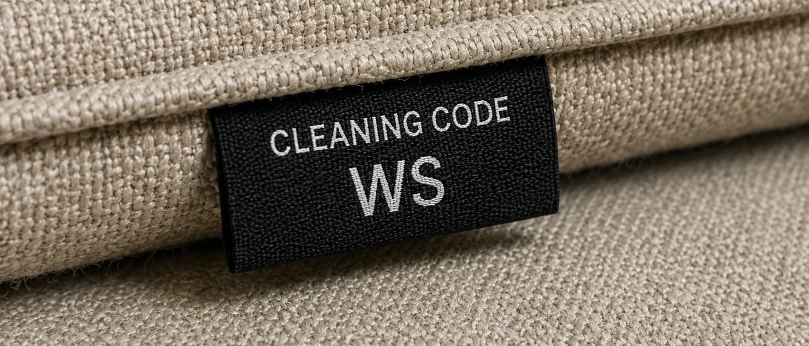 A sewn-in cleaning code tag reading WS on the underside of a woven performance fabric cushion