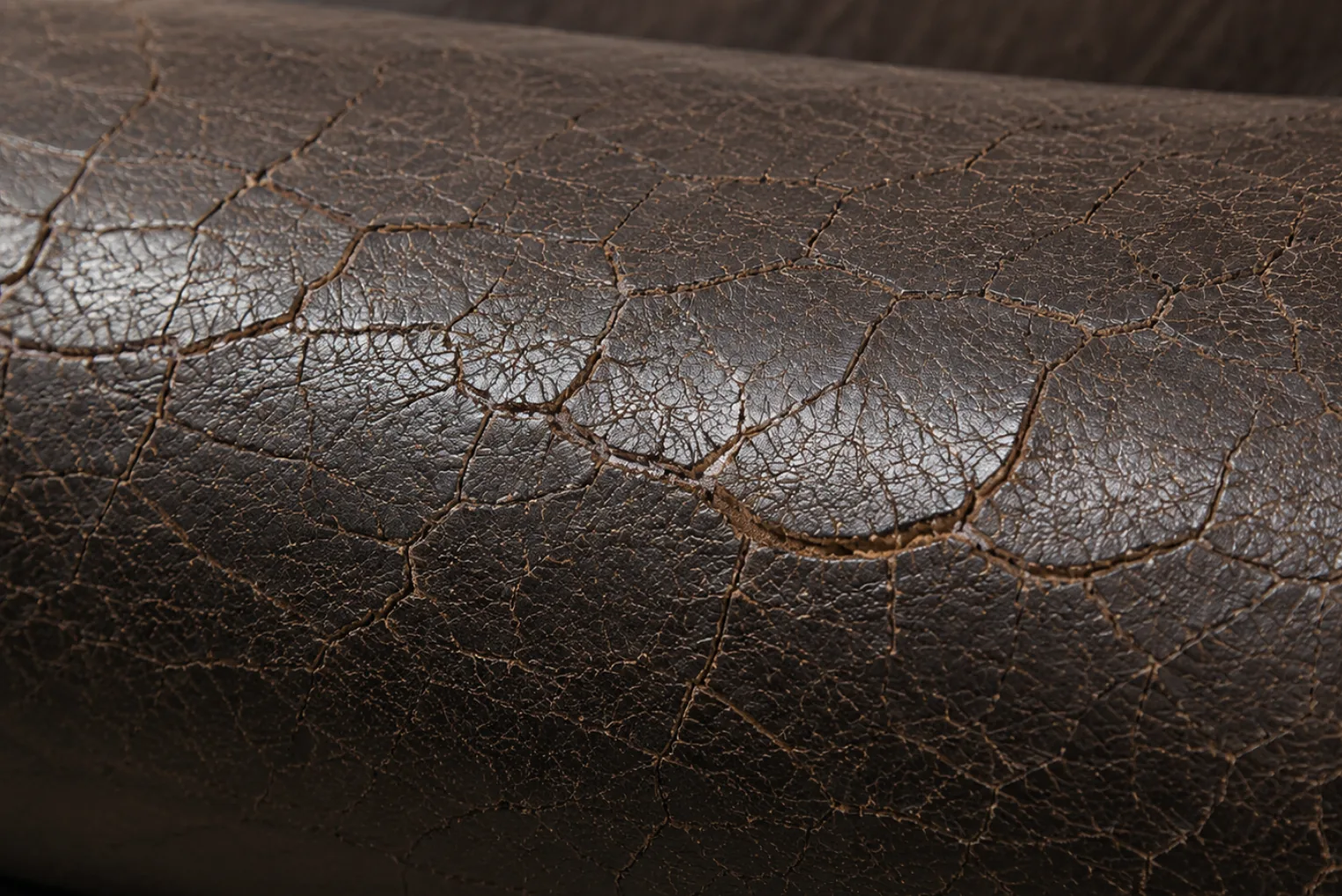 Fine crazing spreading across a stiffened brown PVC vinyl armrest