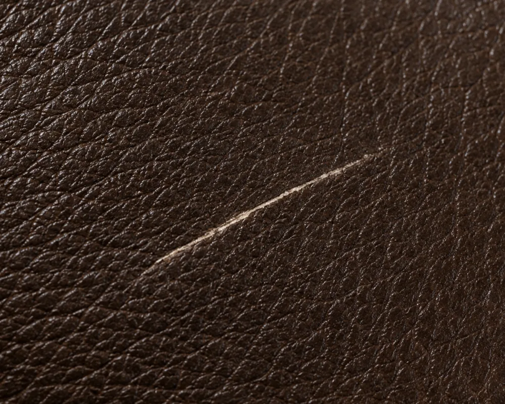 Single shallow scratch across an otherwise intact leather surface