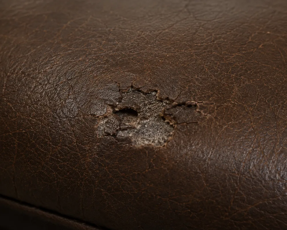 Small contained patch of damaged bonded leather with sound material all around it