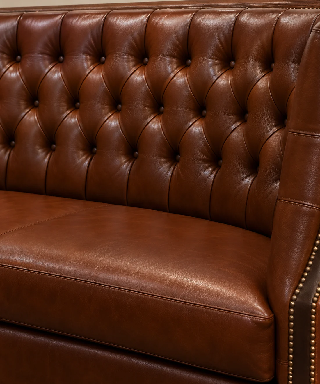 The same chesterfield banquette after reupholstery in even tan leather with the studded edge reset