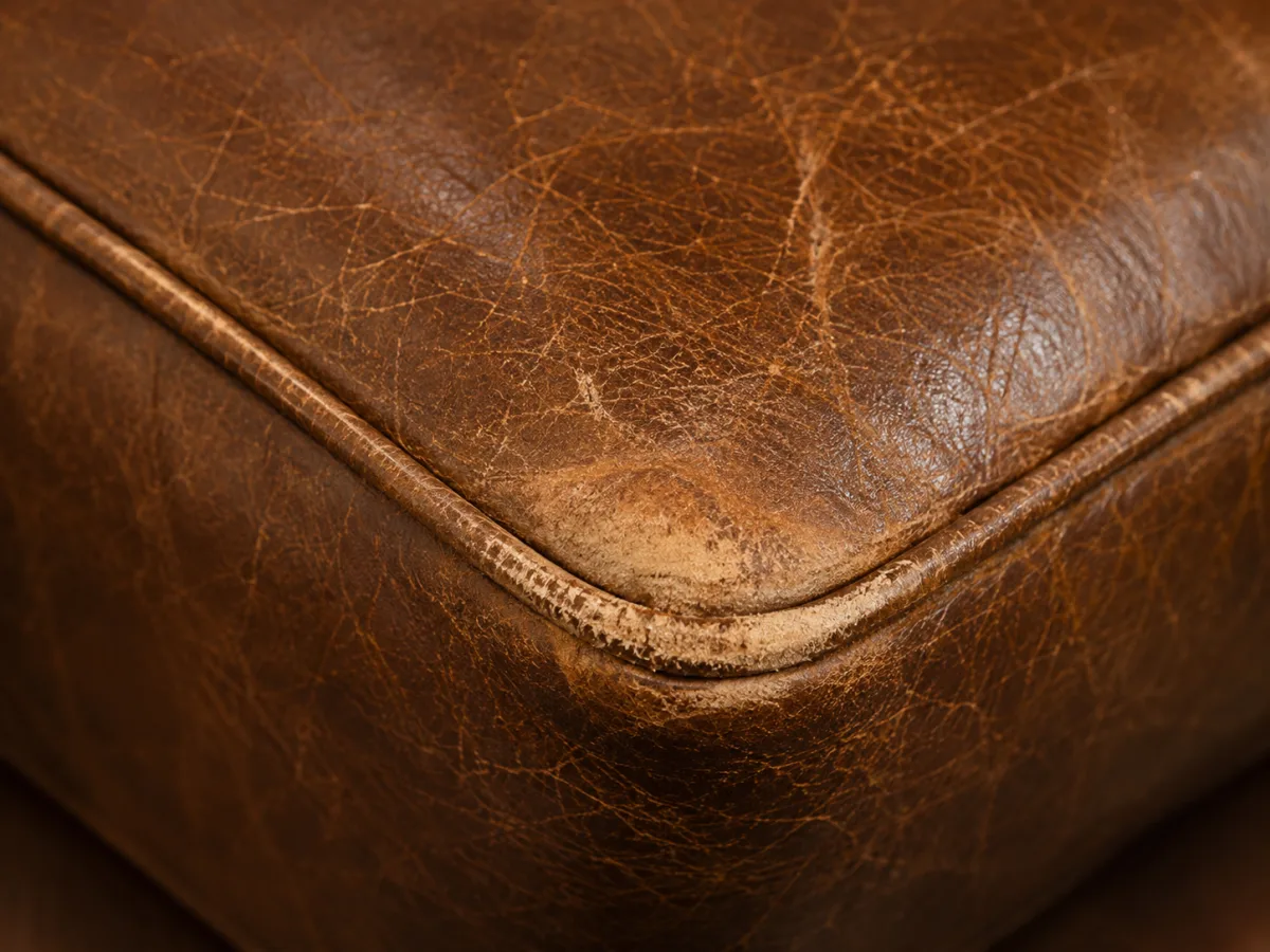 Worn-through corner on a brown leather restaurant booth