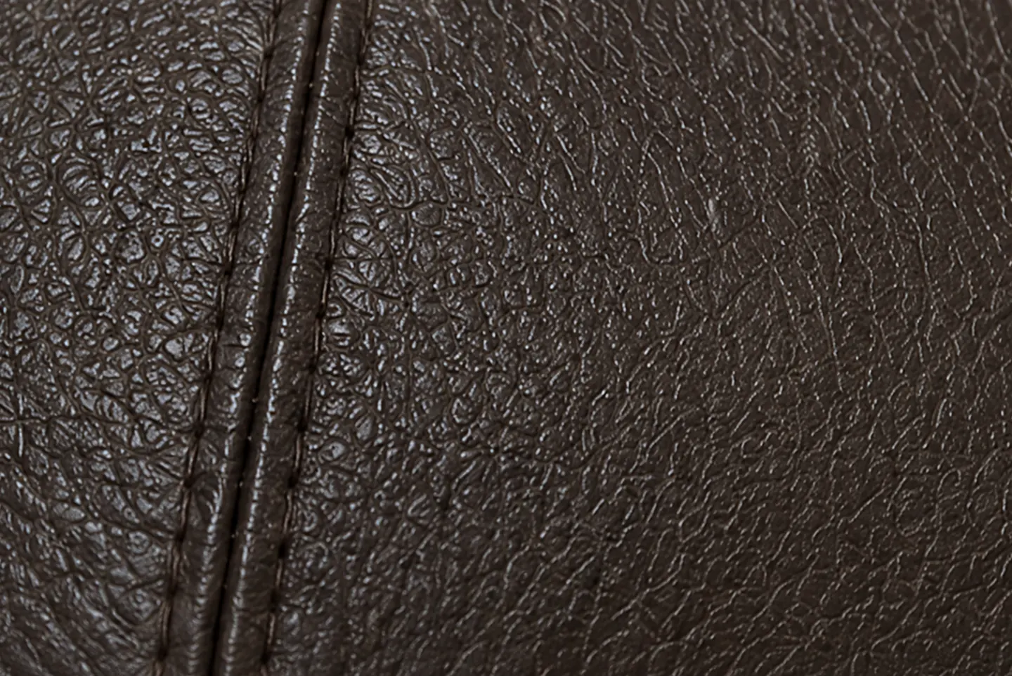 A filled and embossed split under a pigmented coat, the pressed grain even across panel and seam