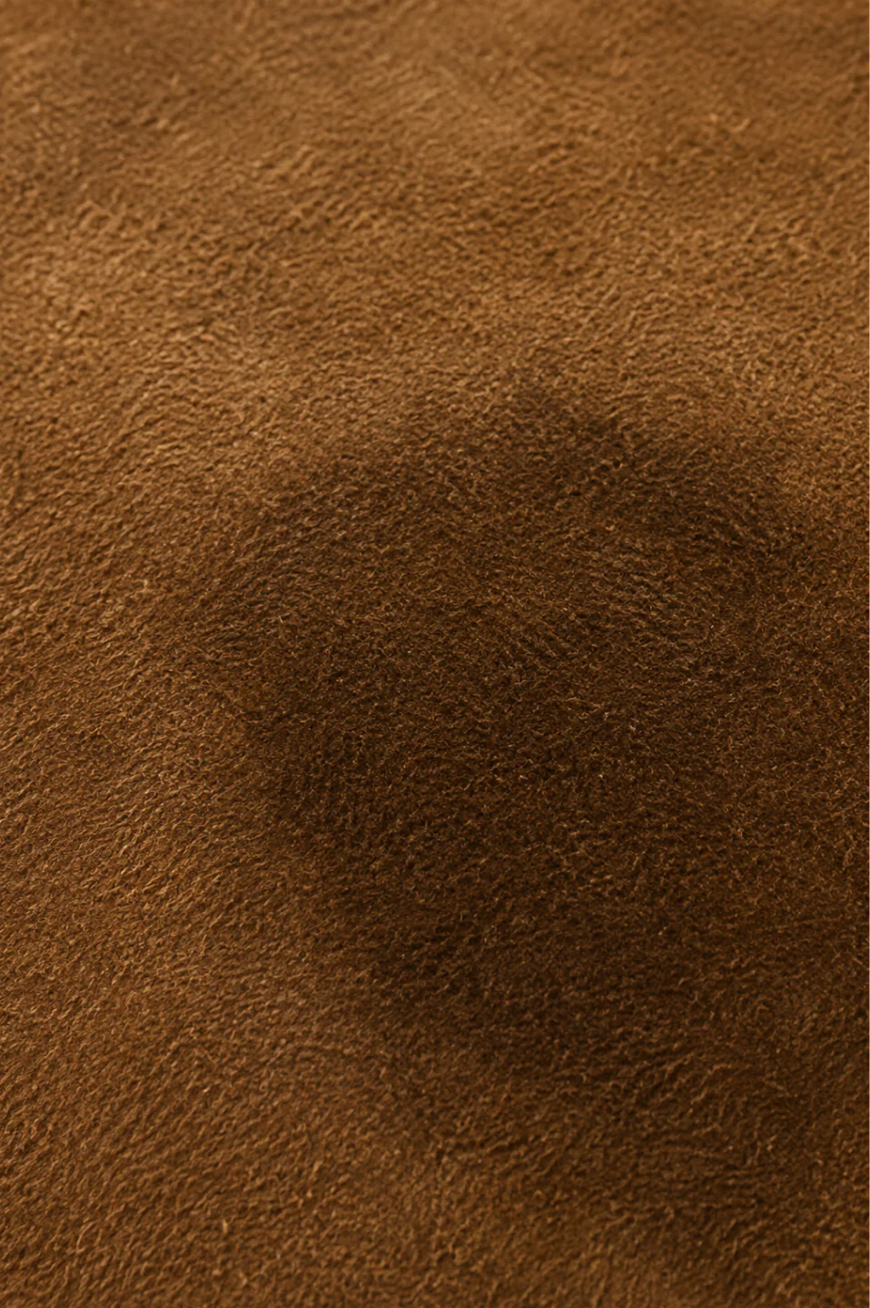 Body oil on suede: a broad darkened area that fades gradually into the surrounding panel with no boundary anywhere