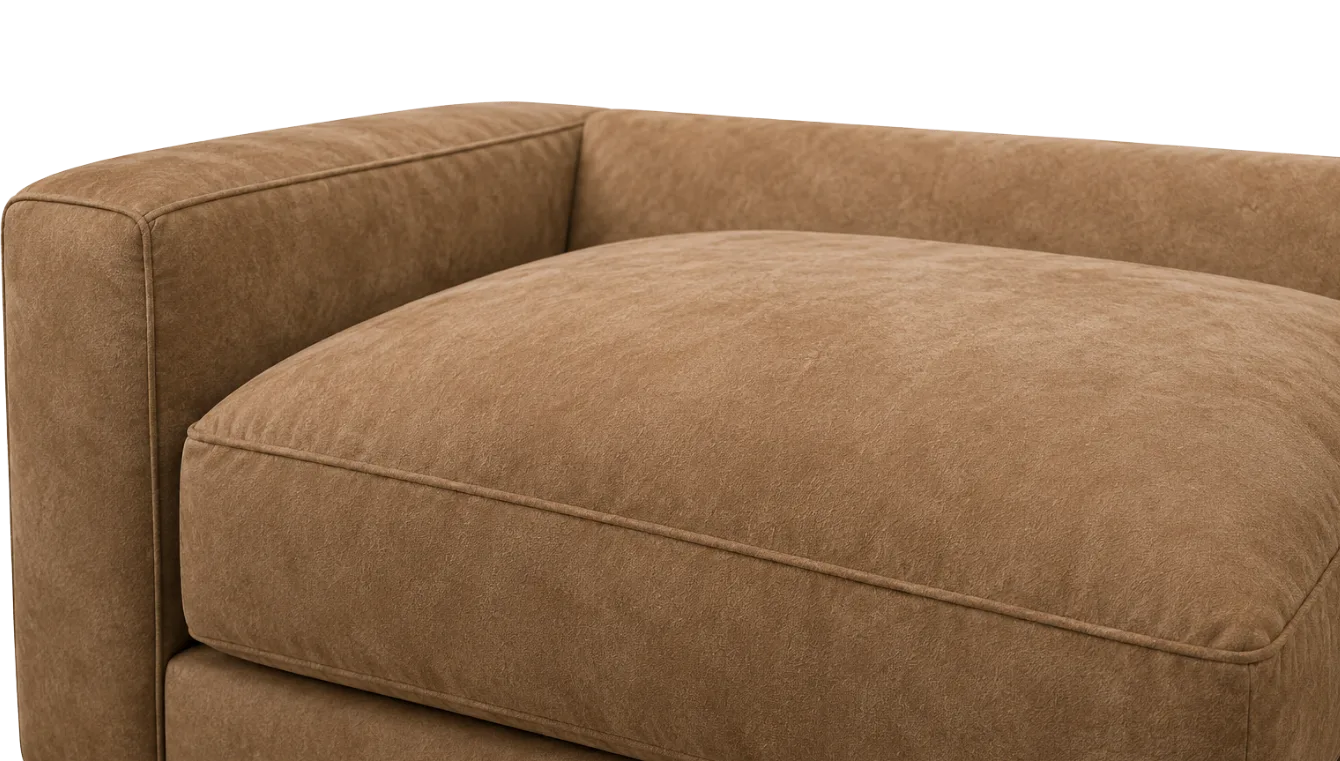 The top of a suede sofa arm, the highest-contact point on the piece and the first place shine appears