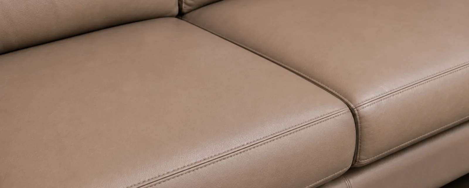 The same taupe sofa after colour restoration, the tone consistent across both cushions