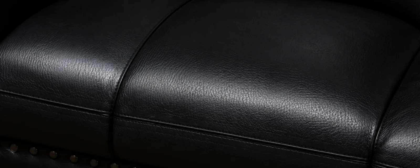 The same black seat panel after the cracks were repaired and the finish rebuilt