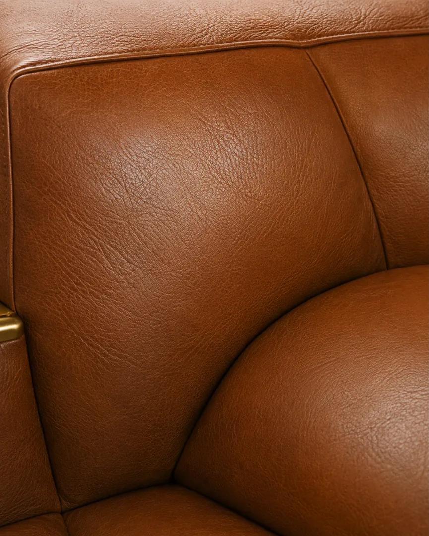 Used top-grain leather armchair showing light creasing and early surface wear where the arm meets the seat