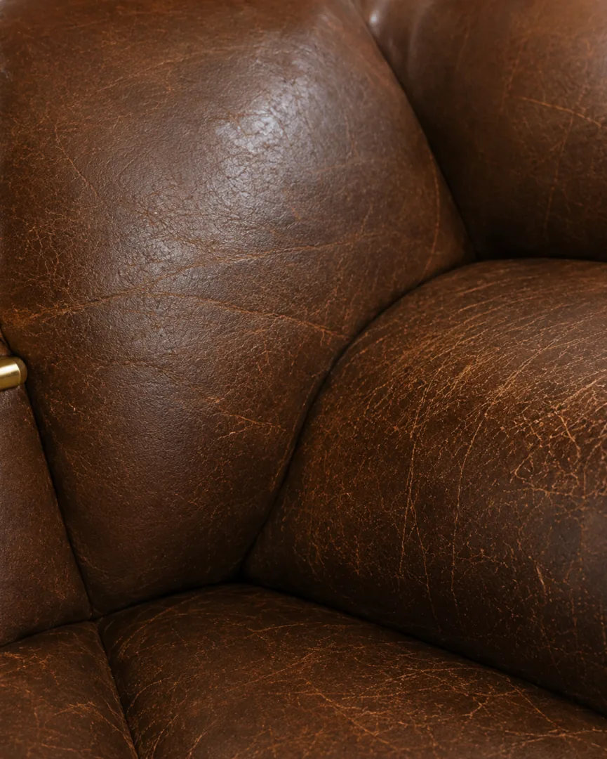 Worn top-grain leather armchair with the finish crazed and darkened across the high-contact seat and arm areas