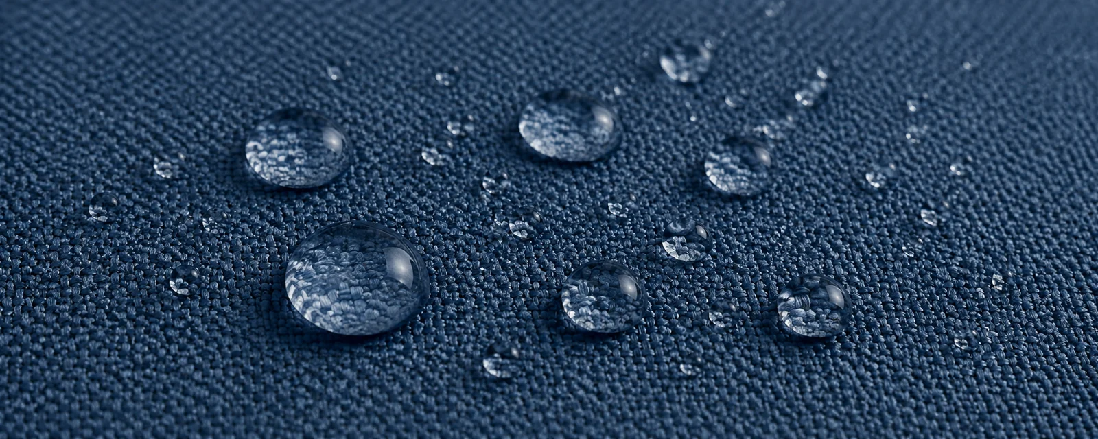 Water beading on the surface of a navy performance upholstery fabric