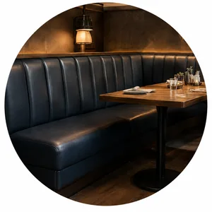 A dark vinyl banquette bench running along a restaurant wall beside a set table