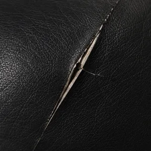 A narrow clean-edged slit cut through black vinyl, the surrounding film unmarked
