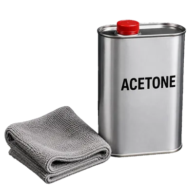 A plain metal solvent can labelled acetone standing beside a folded grey cloth