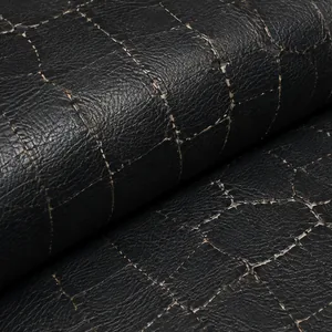 Cracks following the line of a fold behind a black vinyl seat cushion, densest exactly where the panel bends