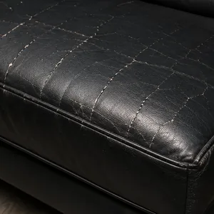 Cracking concentrated along the front edge of a black vinyl seat cushion where it folds under weight