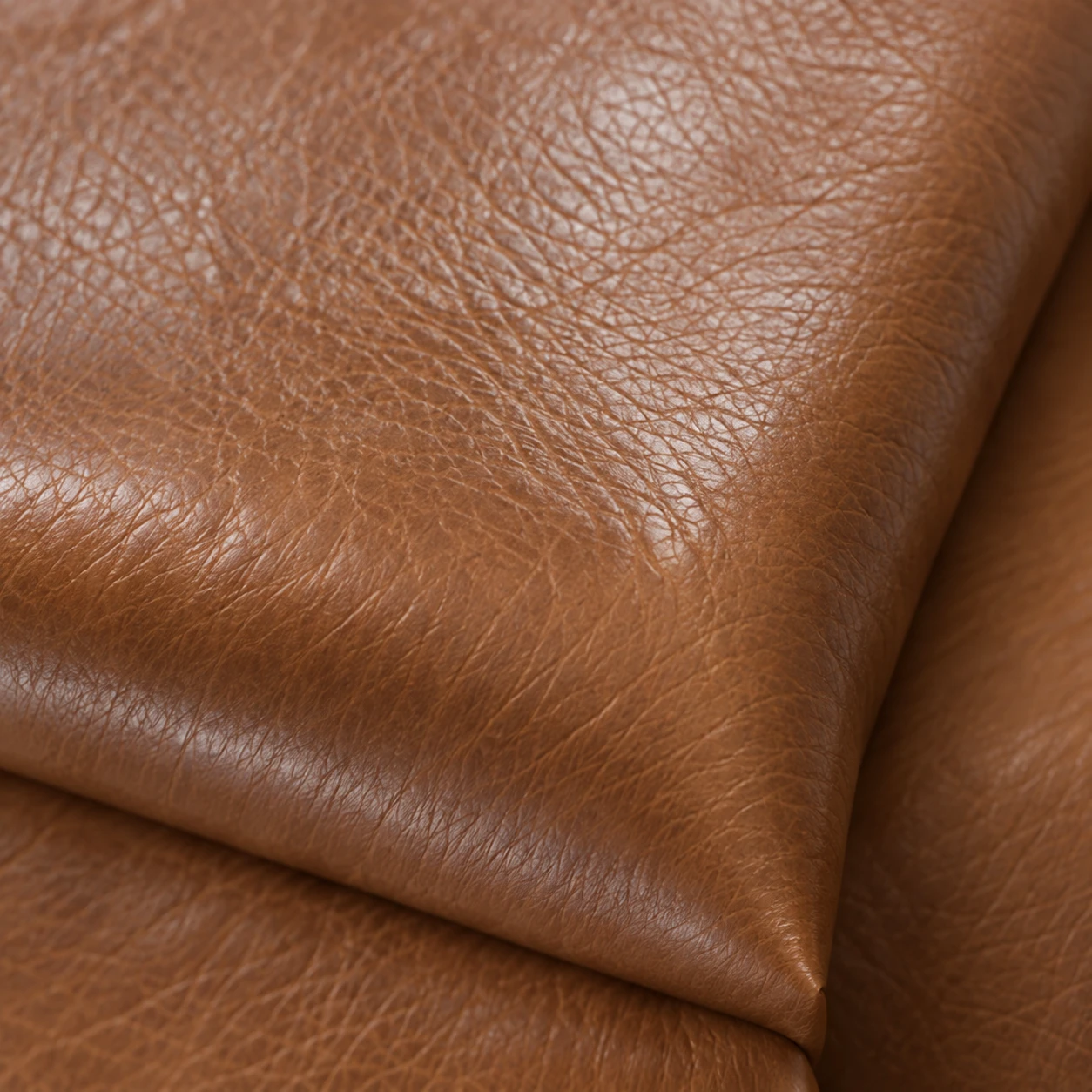 Tan aniline leather swatch with visible pores and no surface coating