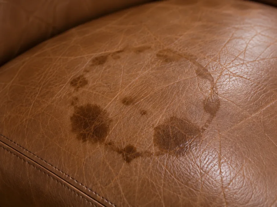 Ring-shaped water mark dried into a tan aniline leather cushion