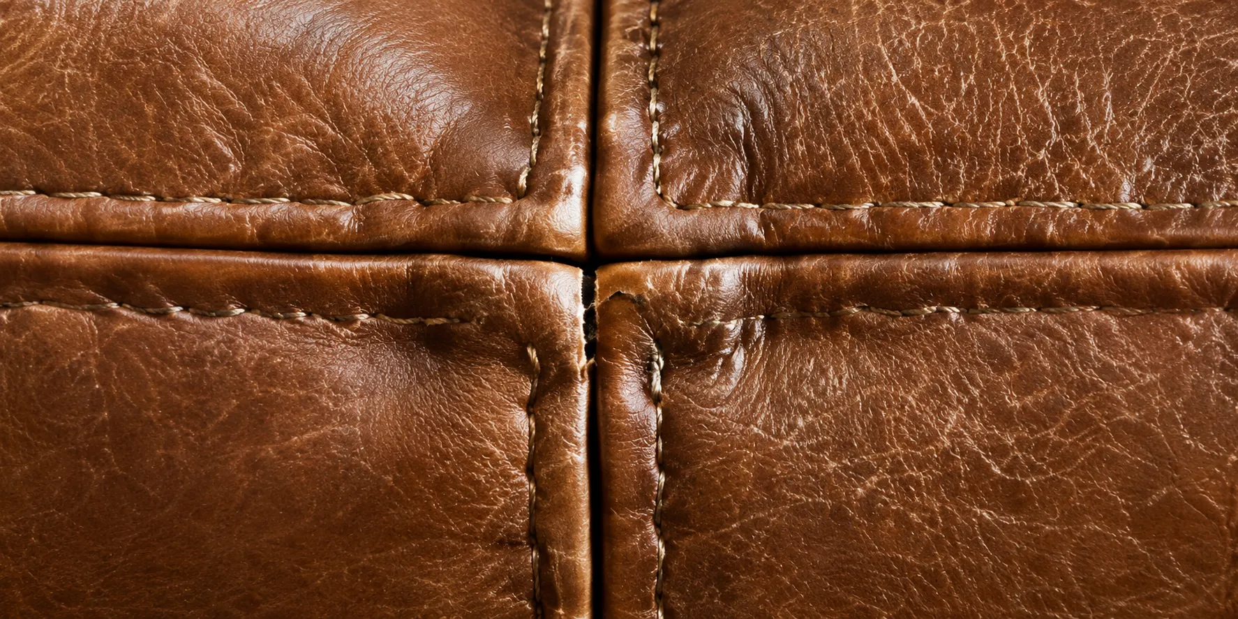 A seam opening where two brown leather panels meet
