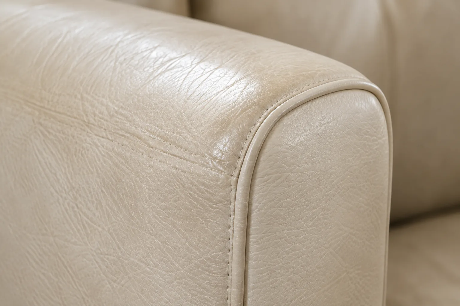 Close view of a cream leather arm showing grain and sheen for color matching