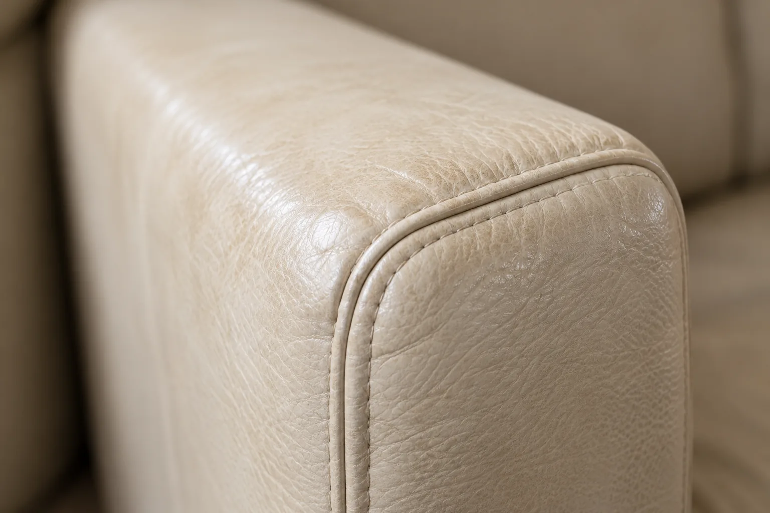 A cream leather armrest being repaired in one small area rather than recovered
