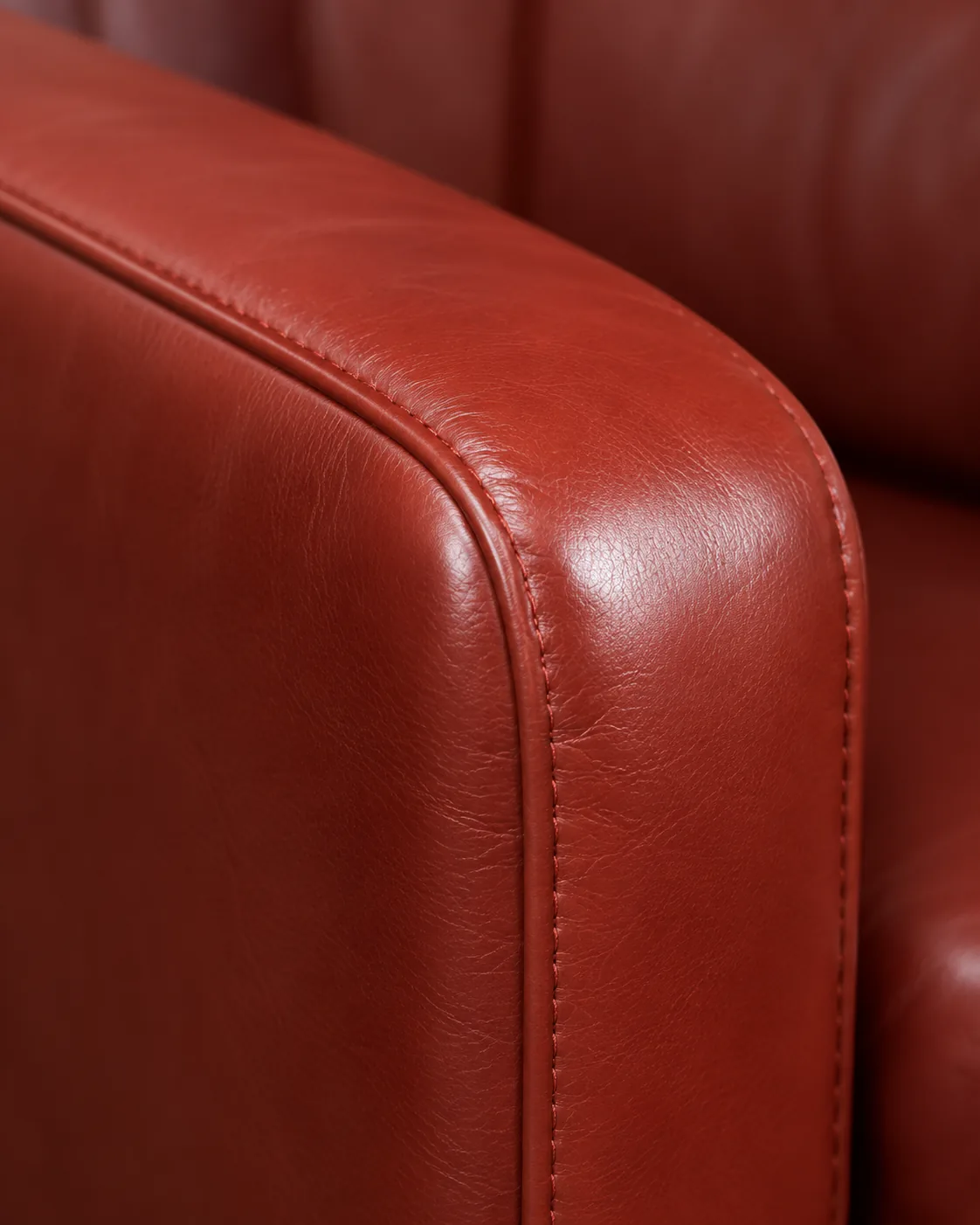 The red leather arm of a lounge chair