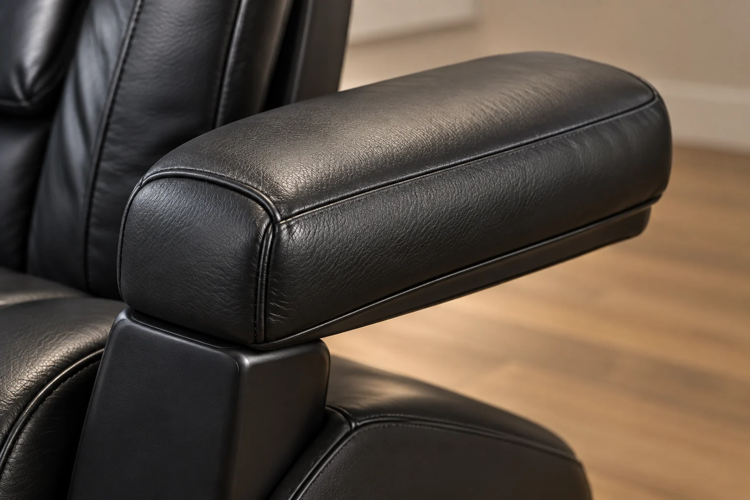 The black leather armrest of a massage chair, clean and undamaged