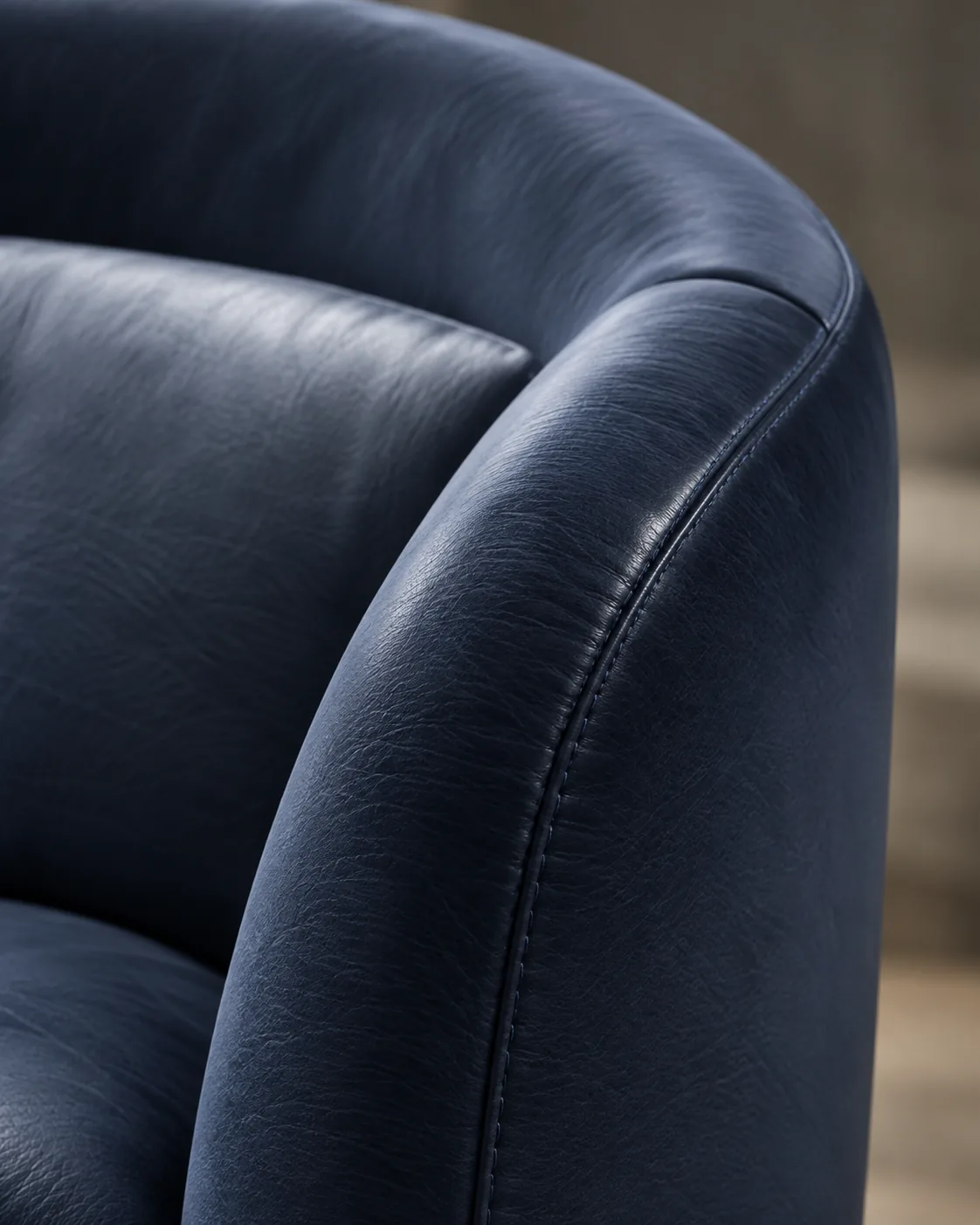 A curved navy leather arm wrapping around the seat